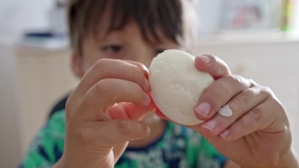 持続性のペイズオフ 若い子供は正常にハードボイルの卵を剥がし 食事を楽しむ始める — ストック動画