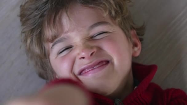 Один Счастливый Мальчик Ухмыляясь Ухмыляясь Сторону Камеры Лежал Полу Глядя — стоковое видео