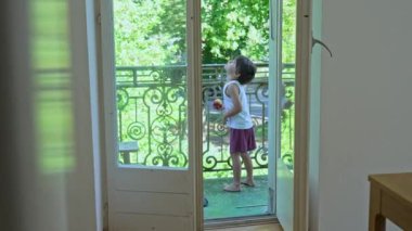 Çocuk balkonda Elma yerken Kuşları izliyor