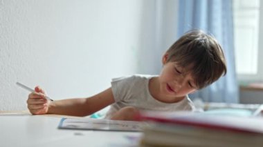 Çocuk, ev ödevi sırasında öğrenme, şarkı söyleme ve dans etme zevkini dile getiriyor.