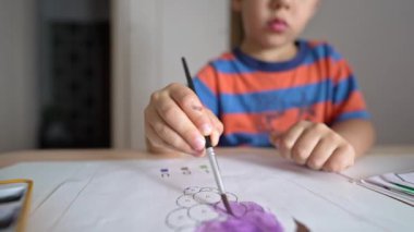 Küçük çocuk çizim kitabını fırça ve Watercolo kullanarak boyuyor.