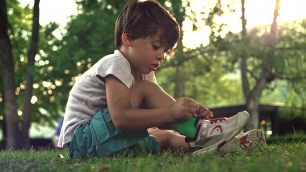Przygotowując Się Wyjazdu Siedząc Trawie Parku Późnym Popołudniem Mały Chłopiec — Wideo stockowe