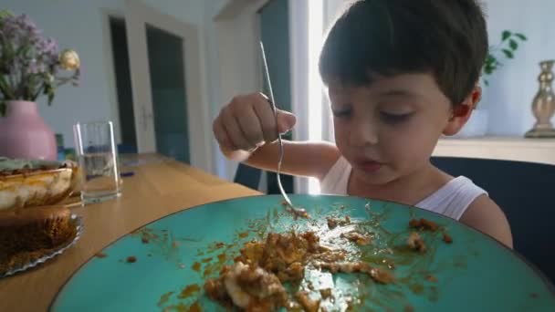 子供が食べ物を食べるためにフォークを使用して自宅の食事で昼食を食べる — ストック動画