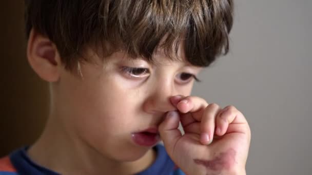 Mały Chłopiec Zarysowuje Nos Zakrytymi Rękami Podczas Malowania — Wideo stockowe
