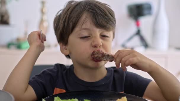 Αγόρι Δαγκώνει Ζουμερό Κομμάτι Από Αρνί Rib Και Ατενίζει Κρέας — Αρχείο Βίντεο