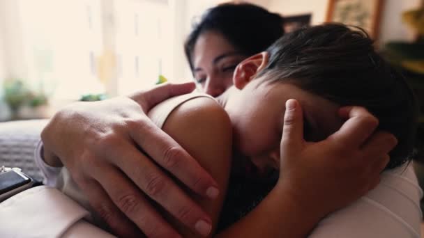 母亲安慰儿子受伤后 父母安慰小男孩躺在妈妈的肩上在家里沙发上 女人用深情的爱和呵护爱抚孩子的皮肤 — 图库视频影像