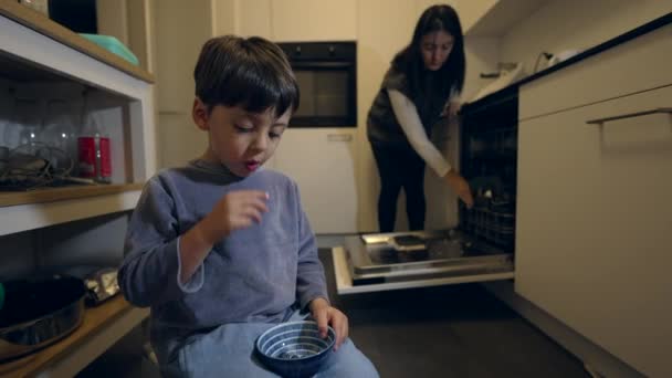 Vida Cotidiana Família Criança Snacking Mirtilos Enquanto Mamãe Arruma Cozinha — Vídeo de Stock