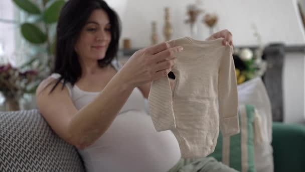 Anne Sevgisi Hamile Bir Kadın Kucağında Bebek Kıyafetleri Ile Evde — Stok video