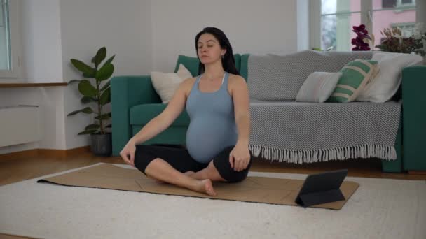 Hamile Kadın Oturma Odasında Yoga Minderinde Kanepenin Yanında Meditasyon Yapıyor — Stok video