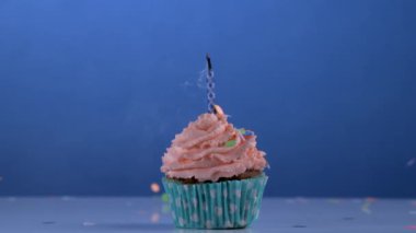 Ağır çekimde doğum günü anı: Mavi Arkaplanlı Kek Üzerine Mumu Söndürme. Sihirli mum kendini tekrar açar, sihirli rahatlatıcı mum.