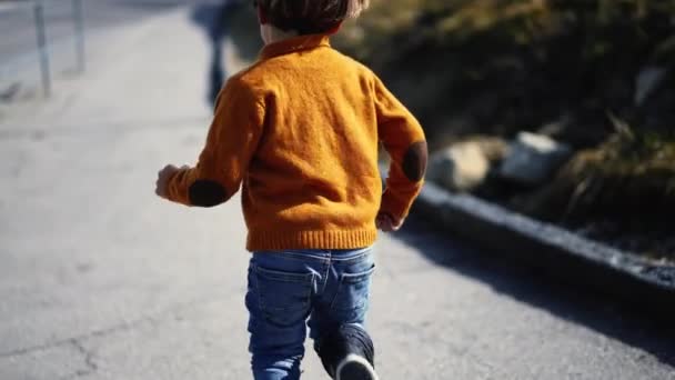 Задняя Часть Беззаботного Маленького Мальчика Выбегающего Наружу Желтом Свитере Сапогах — стоковое видео