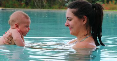 Mother and baby interaction at the swimming pool eskimo kiss