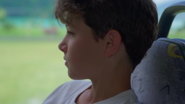 沉思的小男孩坐公共汽车旅行的概况 观察路过的风景 持续不断的十几岁前的孩子旅行 并进行深刻的精神反思 — 图库视频影像