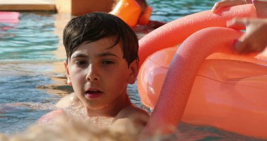 Yüzme havuzundaki genç çocuk samimi ve sıradan