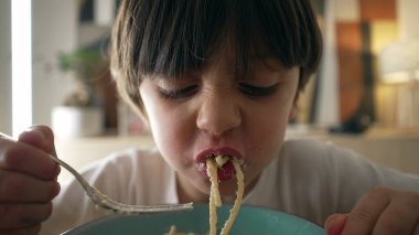Çocuk spagetti yiyor, yemek zamanı, 5 yaşında karbonhidrat zengini bir çocuğun yakın plan yüzü.