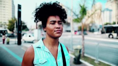 Güney Amerikalı genç bir siyahi kadın şehir merkezinde yürüyen 20 'li yaşlarda bir kadının yakın çekimini takip ediyor.