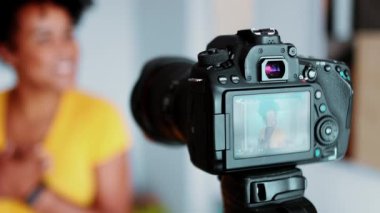 Yakın plan video kayıt cihazı, bulanık arka planda hareketler. Çevrimiçi kanalda yayınlanacak bir video oluşturuluyor. Kadın yeni medya iletişimi ile meşgul, referans paylaşımı