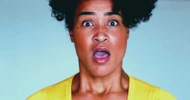 Genç siyahi bir kadın, kameraya direkt olarak ağzı açık ve şok olmuş bir şekilde bakan haberlere olumsuz tepki veriyor. 20 'li yaşların inançsızlığı