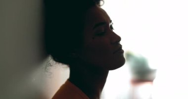 Depresyondaki siyah Latin bir kadın, melankolik bir ifadeyle duvara yaslanıyor. Mesafeye bakıyor. Düşüncelere dalıp gidiyor.