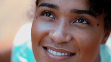 Umut dolu genç bir siyahi kadın gökyüzüne bakıyor. İnanç ve övgüyle. 20 'li yaşlarda neşeli bir Afrikalı' nın yakın plan yüzü.