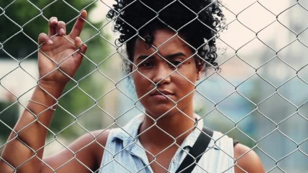 孤独的年轻非洲裔美国妇女站在金属栅栏屏障后感到悲伤和孤独 精神病的概念 — 图库视频影像