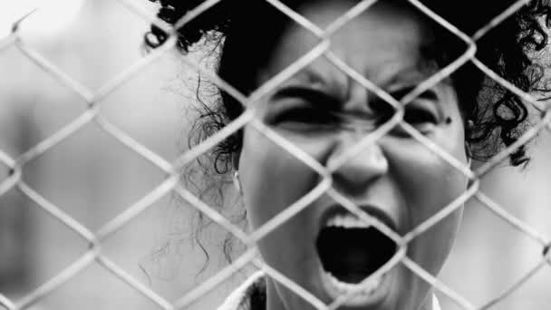 Μια Θυμωμένη Μαύρη Γυναίκα Ακουμπάει Στο Μεταλλικό Φράχτη Ουρλιάζοντας Στην — Αρχείο Βίντεο