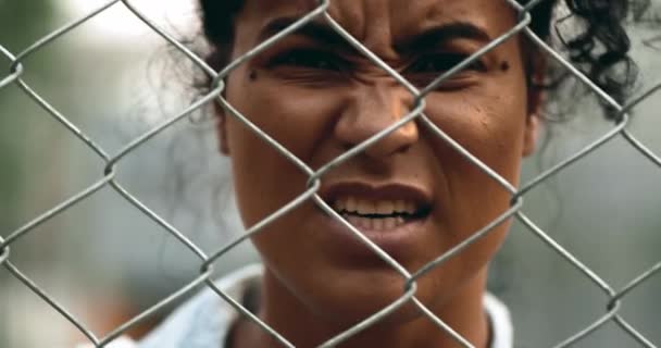 Μια Αναστατωμένη Μαύρη Γυναίκα Φωνάζει Πίσω Από Μεταλλικό Φράχτη Κοιτάζοντας — Αρχείο Βίντεο