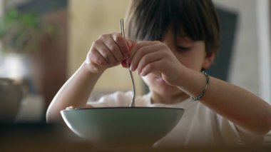 Spagetti zevki - küçük çocuk yemek saatinde makarna yerken çatal çevirmeye çalışıyor. Çocuk eğlenirken çatal bıçak kullanmayı öğren.
