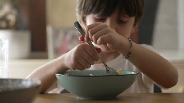 Yemek saatinde spagetti yiyen küçük bir çocuk. Karbonhidratlı makarnanın tadını çıkaran çocuğun yakın plan yüzü.