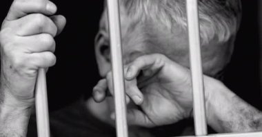 Hapisteki son sınıf öğrencisi zihinsel mücadele sırasında çaresizlik hissederek demir parmaklıklar ardında gözyaşlarını siliyor. 70 'lerin yaşlı insanı umutsuzluğa düştü.