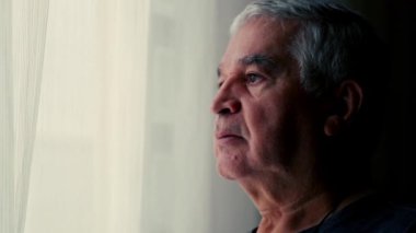 Pencereden dışarı bakan düşünceli yaşlı adam, Emeklilik sırasında derin düşüncelere dalmış.