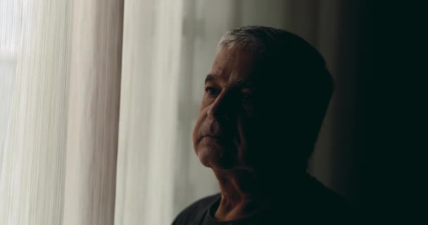 Samotny Przygnębiony Starzec Stojący Przy Oknie Okryty Cieniem Spoglądający Zewnątrz — Wideo stockowe