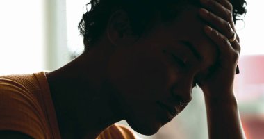 Depresyonda olan genç bir kadın akıl hastalığından muzdarip. Stres ve sessiz umutsuzluktan bunalmış bir siyahi, elleriyle başını tutuyor.