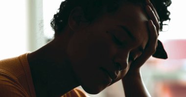 Depresyonda olan genç bir kadın akıl hastalığından muzdarip. Stres ve sessiz umutsuzluktan bunalmış bir siyahi, elleriyle başını tutuyor.