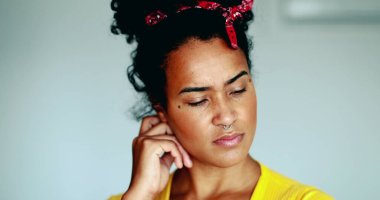 Düşünceli genç Afrikalı Amerikalı kadın, zihinsel tefekküre el sıkışarak sorunu çözmeye çalışıyor. 20 'li yaşlarda siyah Latin bir kızın yakın plan yüzü.