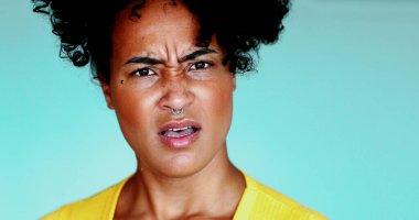 Şaşırtıcı habere tepki veren, 20 'li yaşlarda şaşkın bir genç siyahi kadın, kameraya açık ağızla bakan Brezilyalı bir kadının yakın çekim yüzü.