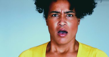 Genç siyahi bir kadın, kameraya direkt olarak ağzı açık ve şok olmuş bir şekilde bakan haberlere olumsuz tepki veriyor. 20 'li yaşların inançsızlığı