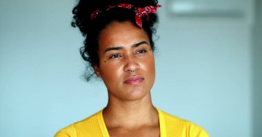 Düşünceli, genç, siyah Brezilyalı bir kadın derin bir zihinsel tefekkür içinde. Afrika kökenli bir kadının düşünceli portresi, uzaktan bakıyor.