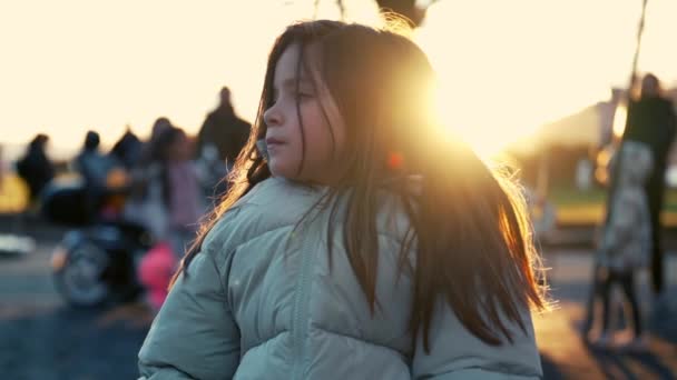 Besinnliches Kleines Mädchen Auf Parkbank Wintersonnenuntergang Verschwommener Spielhintergrund Hintergrundbeleuchtung Einer — Stockvideo