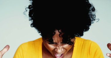 Kızgın genç siyah bir kadın kameraya bağırıyor elleri bağrışırken perişan oluyor. Afrika kökenli 20 'li yaşlarda