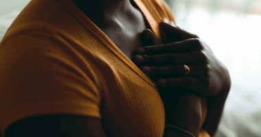 Genç siyahi bir kadın ellerini göğsüne koyuyor. Umutla ve sevgiyle, Afrikalı Amerikalı 20 'li yaşlara özen gösteren barışçıl bir sembol.