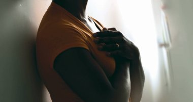 Ruhsal bir genç siyahi kadın ellerini göğsüne koyuyor ve gratitude hissediyor. İçten bir Afrikalı Amerikalı duvarlara yaslanmış yürekten bir tefekkür hissediyor.