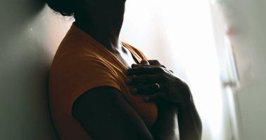 Ruhsal bir genç siyahi kadın ellerini göğsüne koyuyor ve gratitude hissediyor. İçten bir Afrikalı Amerikalı duvarlara yaslanmış yürekten bir tefekkür hissediyor.