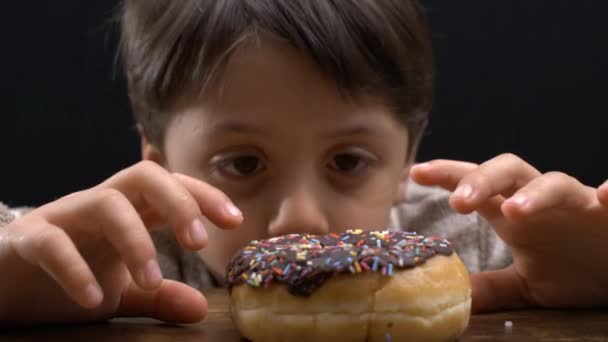 5歳児の忍耐力 テーブルに甘いドーナツを予想する — ストック動画