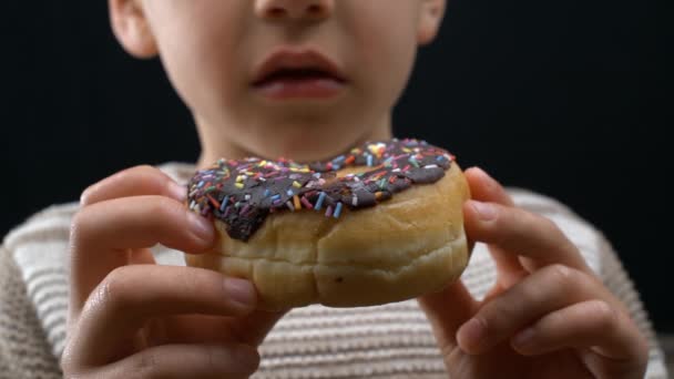 スウィート ドーナツを着用した患者 ヤング ボーイは 遅延した満足感を取り入れた 砂糖のラッシュを予想する食品炭水化物スナックを持っている子供 — ストック動画