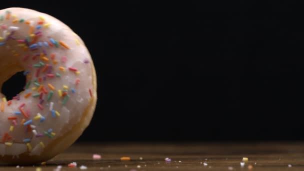 大甜甜圈从左到右在黑色背景上滚动 慢镜头拍摄 碳水化合物食物处理 — 图库视频影像