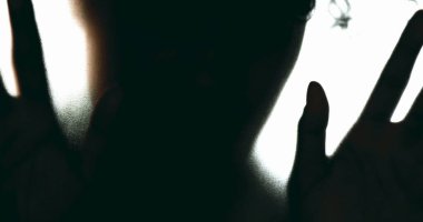 Çözülmüş camın arkasında kapana kısılmış hisseden kişi, depresyon psikolojisi konsepti akıl hastalığıyla mücadele eden kişi çaresizlik içinde tek başına acı çekiyor.