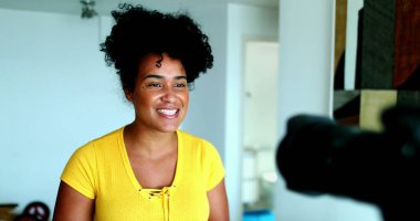 Kameranın önünde konuşan genç siyah bir kadın online kanal için ifade veriyor. 20 'li yaşlardaki kadın vlog kaydedicisi yeni medyayla bağlantı kuruyor