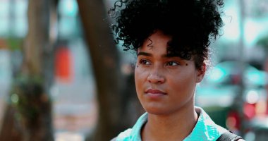 Düşünceli bir genç siyah Brezilyalı kadın, Sunny Day 'de sessizce Park' a bakıyor, Düşüncelere dalmış. Afrika kökenli 20 'li yaşlarda