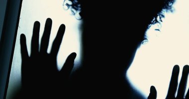 Camın arkasında kapana kısılmış, elleri eğilmiş depresif ve çaresizce dışarı çıkmak isteyen bir kadın. Umutsuzluk ve yalnızlıktan muzdarip insan zihinsel hastalık konsepti